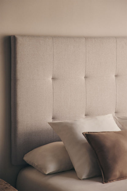 Détail du capitonnage d'une tête de lit en tissu