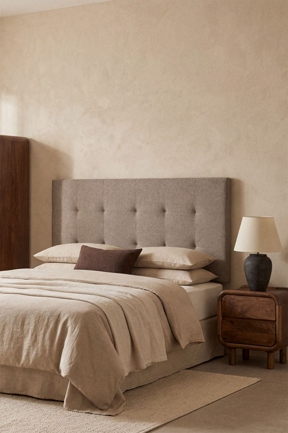 Tête de lit capitonnée brun moka installée dans une chambre