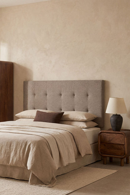 Tête de lit capitonnée brun moka installée dans une chambre